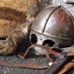 black steel helmet near black and gray handle sword